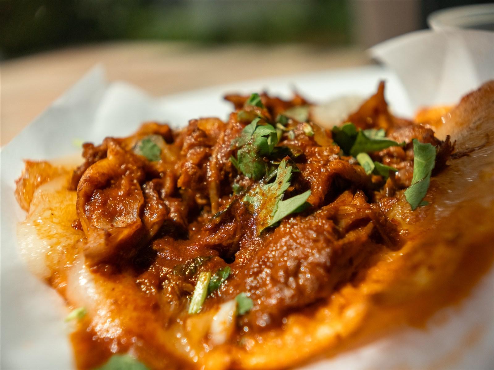 Birria queso taco with melted cheese and cilantro