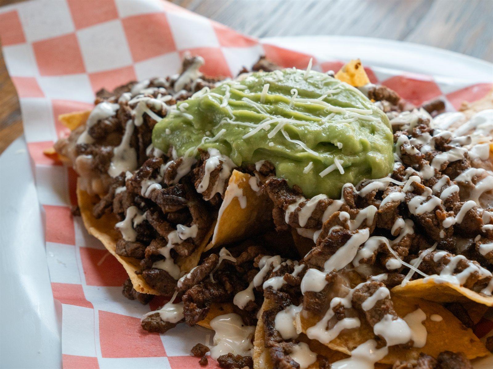 Asada nachos with guacamole and crema
